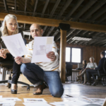 Business people reviewing proofs on floor in office